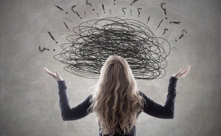 Femme de dos face à un nuage de pensées emmêlées dessiné au-dessus de sa tête