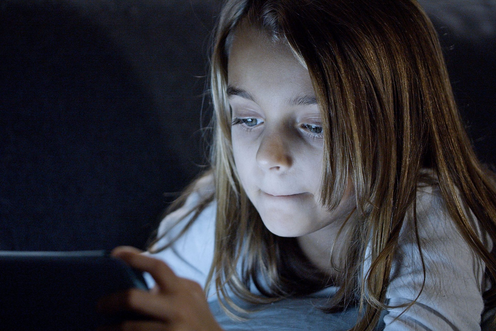 Enfant tenant une tablette très près de son visage, signe possible d'un trouble neurovisuel