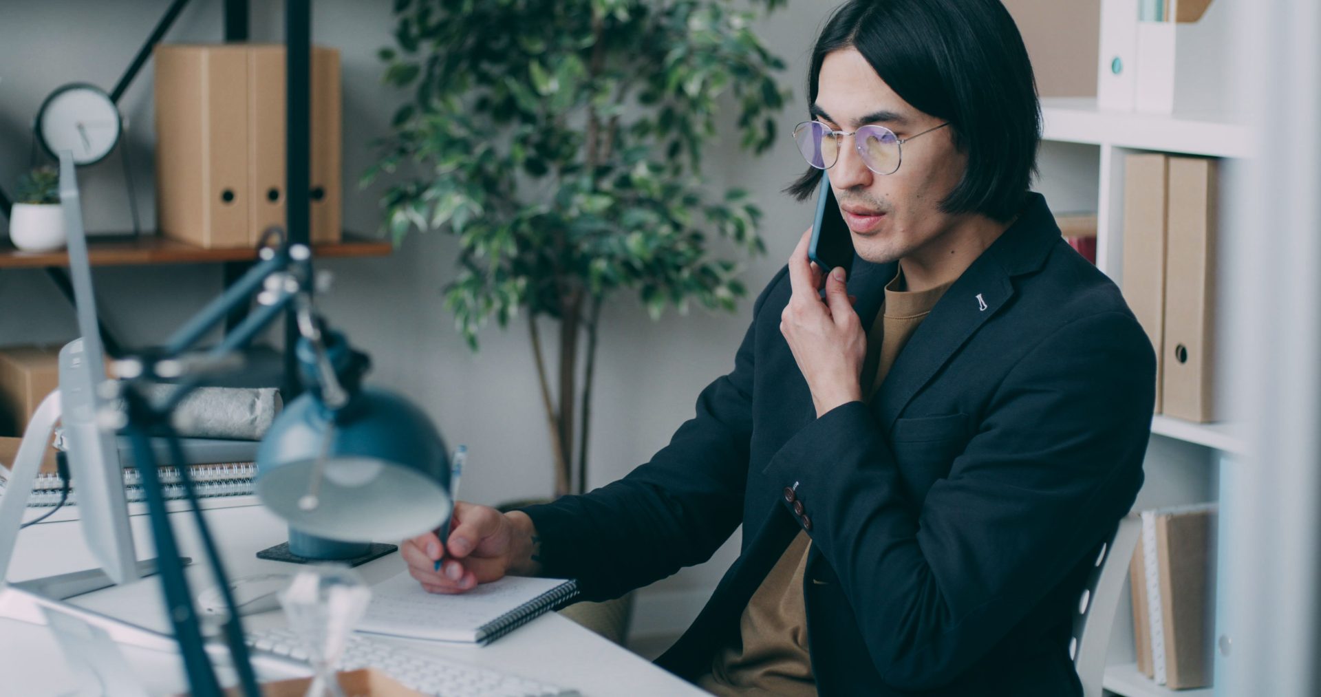 Homme d'une quarantaine d'années au téléphone à son bureau, fatigue et concentration