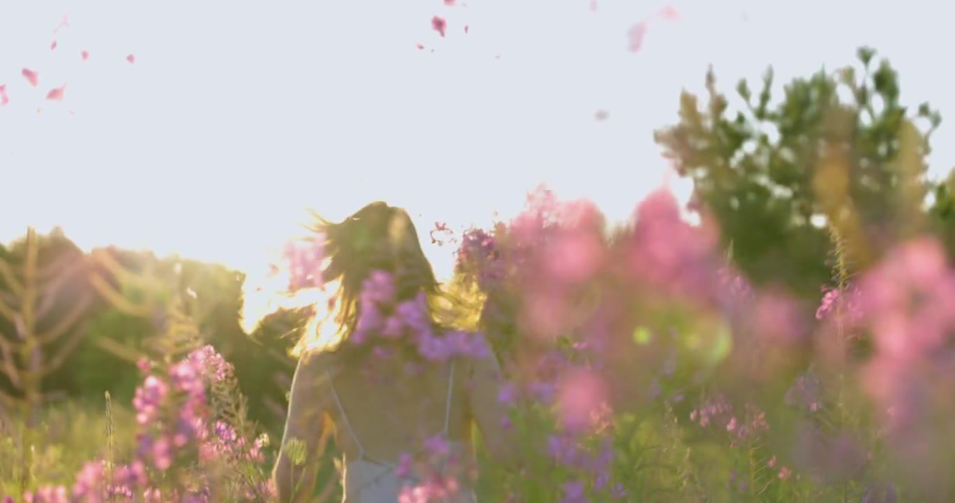 Une femme dans un champ de fleurs, dans la lumière du soir