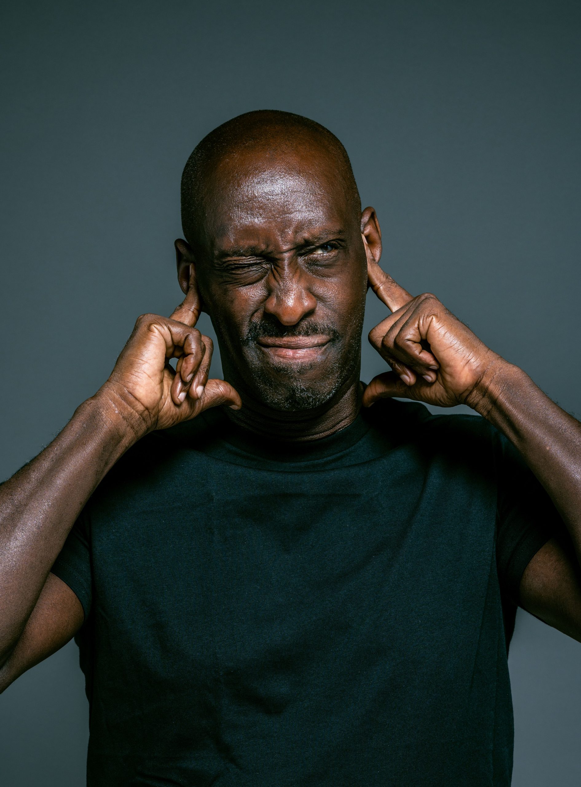 Homme qui se bouche les oreilles avec les doigts, agacé par le bruit