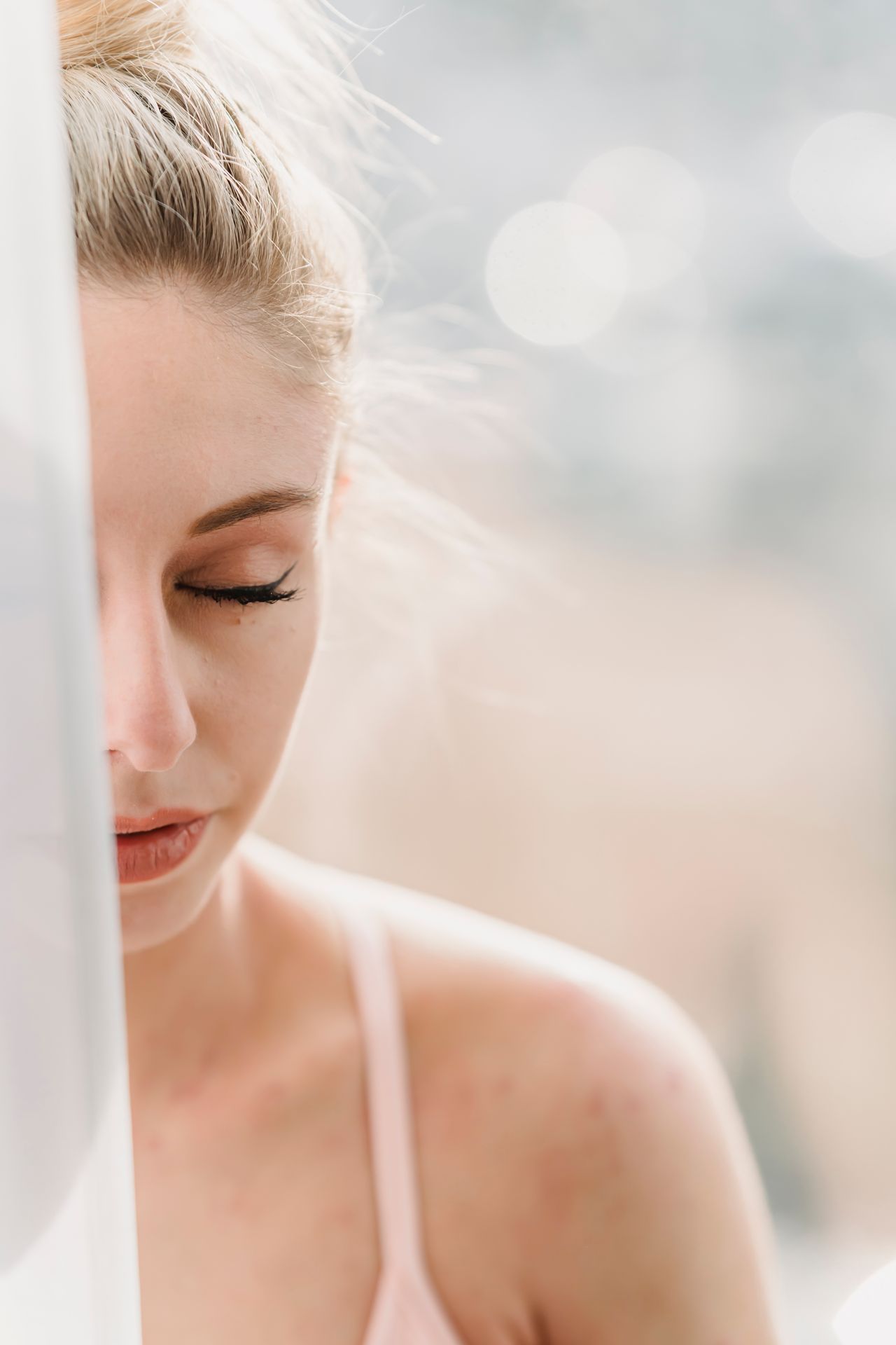 Femme apaisée, les yeux fermés, dans la lumière du matin