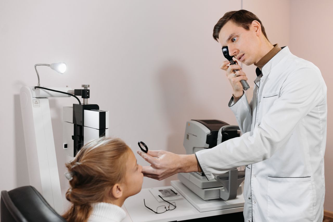 Un médecin examine les yeux d'une petite fille dans un cabinet lumineux